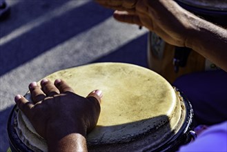 Drum player playing atabaque during presentation of afro music on the eve of the Brazilian carnival