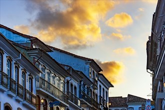 Glows and reflections over old colonial style houses with their balconies in the traditional historic town of Ouro Preto during sunset