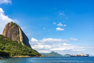 Cargo ship entering Guanabara Bay and passing between the mountains and Sugar Loaf hill in Rio de Janeiro
