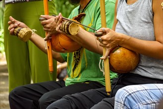 Musicians playing Afro Brazilian percussion musical instruments called berimbau during a capoeira performance in the streets of Brazil
