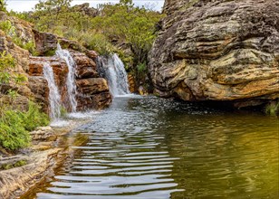 Waterfall among the vegetation and strong rocks of the Biribiri environmental reserve in Diamantina
