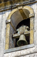 Colonial-style church tower with old bell in the city of Ouro Preto in Minas Gerais