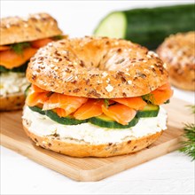 Bagel sandwich for breakfast topped with salmon fish on a board square in Stuttgart