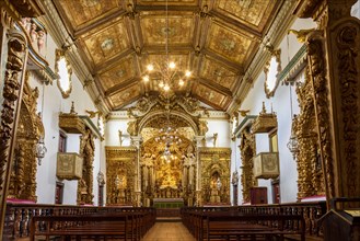 Interior and altar of a brazilian historic ancient church from the 18th century in baroque architecture with details of the walls in gold leaf in the city of Tiradentes