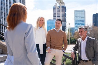 Cheerful group of coworkers outdoors in a corporate office area resting