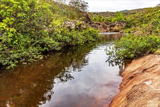 River between the rocks and the arid vegetation of the Biribiri environmental reserve in Diamantina