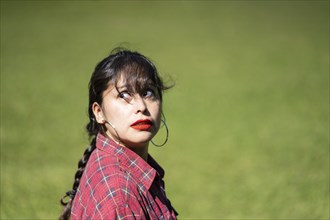 Portrait of andean woman posing in a park. Model striking a pose in a park