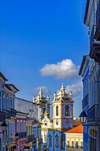 Colorful houses facades and historic church towers in baroque and colonial style with blue sky in the famous Pelourinho district of Salvador