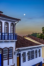 Nightfall in the historic city of Ouro Preto in the state of Minas Gerais with the full moon in the sky and the facade of old colonial style houses