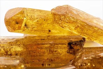 Studio photography of Brazilian imperial topaz in raw state with white background