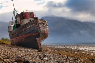 Stranded fishing boat and Ben Nevis from the shore of Loch Linnhe