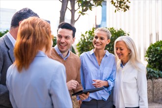 Cheerful group of coworkers laughing and having fun outdoors in a corporate office area