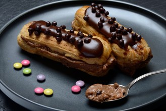 Two chocolate eclairs on a plate