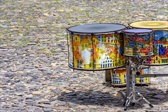 Ethnic drums decorated with paintings on the cobblestones of the Pelourinho slopes in Salvador