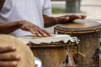 Percussionist playing a rudimentary atabaque during afro-brazilian capoeira fight presentation in the streets of Pelourinho in Salvador city