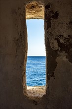 A window to the sea. View of the sea and horizon in the guardhouse of an old fortress from the 17th century in the city of Salvador