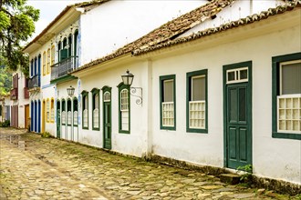 Rua bucolica com calcamento de pedras e casas historicas em estilo colonial da epoca do imperio na cidade de Paraty no litoral do Rio de Janeiro