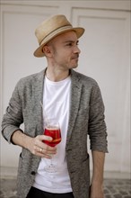 Man with a hat and a glass of Aperol Spritz