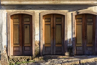 Old wooden doors spoiled by time on the facade of a colonial style house in the city of Ouro Preto
