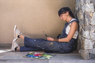 Portrait of a woman artist siting on the floor outdoors
