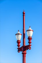 Old red street lamp with blue sky in the background in the city of Belo Horizonte