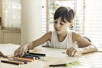 Child drawing in a bright environment. A safe and welcoming environment fosters the development and free expression of children