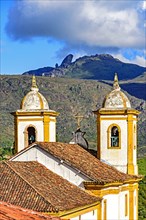 View of one of several churches and your bell tower in baroque and colonial architecture of the city of Ouro Preto in Minas Gerais with its mountains in the background