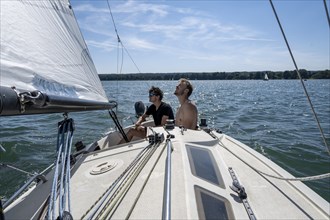 Two young men sailing on a sailboat