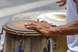 Musician playing a traditional Brazilian percussion instrument called atabaque during a capoeira performance on the streets of Pelourinho in Salvador