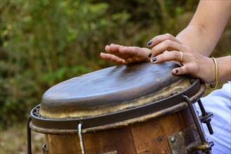 Woman percussionist hands playing a drum called atabaque during brazilian folk music performance