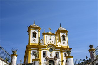 Bottom view of the facade of historic church in baroque style with blue sky in the background in Ouro Preto city in Minas Gerais