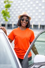 Black woman with sunglasses opening car door