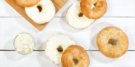 Bagel sandwich for breakfast topped with cream cheese on wooden board Panorama from above in Stuttgart