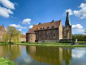 View of historical moated castle from Renaissance Raesfeld Castle reflected in moat in spring