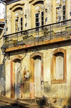 Facade of old house in colonial architecture worn by time in the city of Ouro Preto