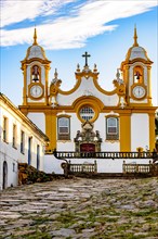 Facade of a historic church in baroque style built in the 18th century cobblestone street with houses in the city of Tiradentes in Minas Gerais