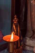 Image of our lady appeared on an altar lit by a candle during religious worship in the interior of Brazil