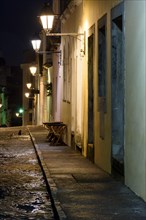 Old cobblestone street with colonial houses lit at night in the Pelourinho district of Salvador
