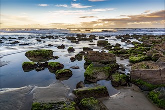 Quiet and deserted beach with rocks during sunset in the city of Torres in Rio Grande do Sul