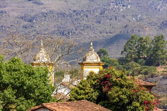 One church tower of the many historic churches in baroque and colonial style from the 18th century amid the hills and vegetation of the city Ouro Preto in Minas Gerais