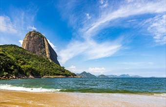 Sugarloaf hill seen from Red beach in the neighborhood of Urca with the mountains of Rio de Janeiro in the background on a sunny day