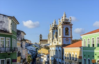 Colorful and ancient colonial houses facades and historic church towers in baroque and colonial style with blue sky in the famous Pelourinho district of Salvador