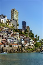 Slum over the sea of the city of Salvador in Bahia with the buildings in the background on a sunny afternoon