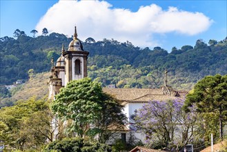 One of the many historic churches in baroque and colonial style from the 18th century amid the hills and vegetation of the city Ouro Preto in Minas Gerais