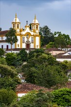 Historic colonial-style church surrounded by houses and greenery in the city of Tiradentes in Minas Gerais