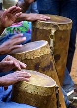 Percussionists group playing a rudimentary atabaque made with leather and wood during afro-brazilian cultural manifestation