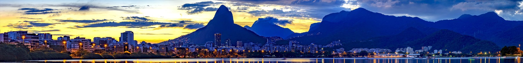 Panoramic image of summer sunset seen from the lagoon Rodrigo de Freitas with the buildings of the city of Rio de Janeiro