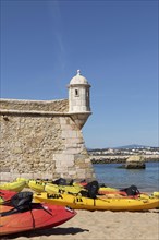 Kayaks on the sandy beach next to the Forte da Ponta da Bandeira