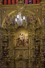 Interior of a baroque church decorated with images of saints and walls with gold leaf ornaments in the historic city of Ouro Preto