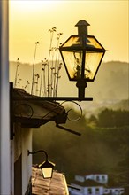 Old street lighting with lantern in colonial style during sunset in the city of Ouro Preto